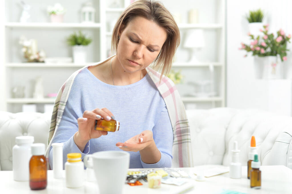 mujer joven enferma tomando píldoras
 - Foto, Imagen