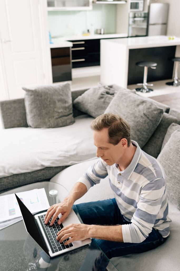 freelancer digitando no teclado do laptop na sala de estar
  - Foto, Imagem
