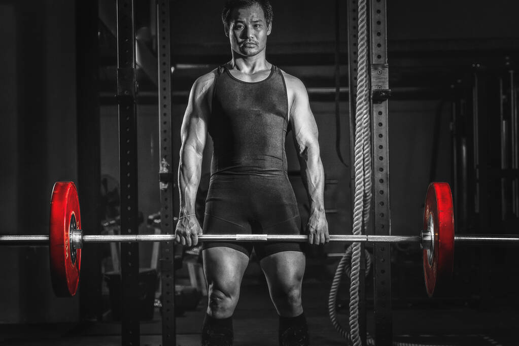 asiatique athlétique fort homme ayant séance d'entraînement et de musculation avec haltérophilie style dans la salle de gym et fitness club dans le ton sombre
 - Photo, image