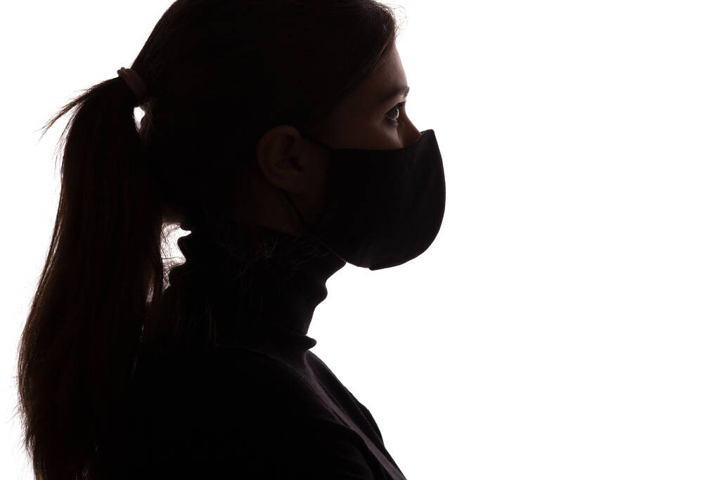 силует профіль молодої жінки в захисній масці, що покриває обличчя на студійному фоні, дівчина виглядає як шпигун агент, концепція безпеки
 - Фото, зображення