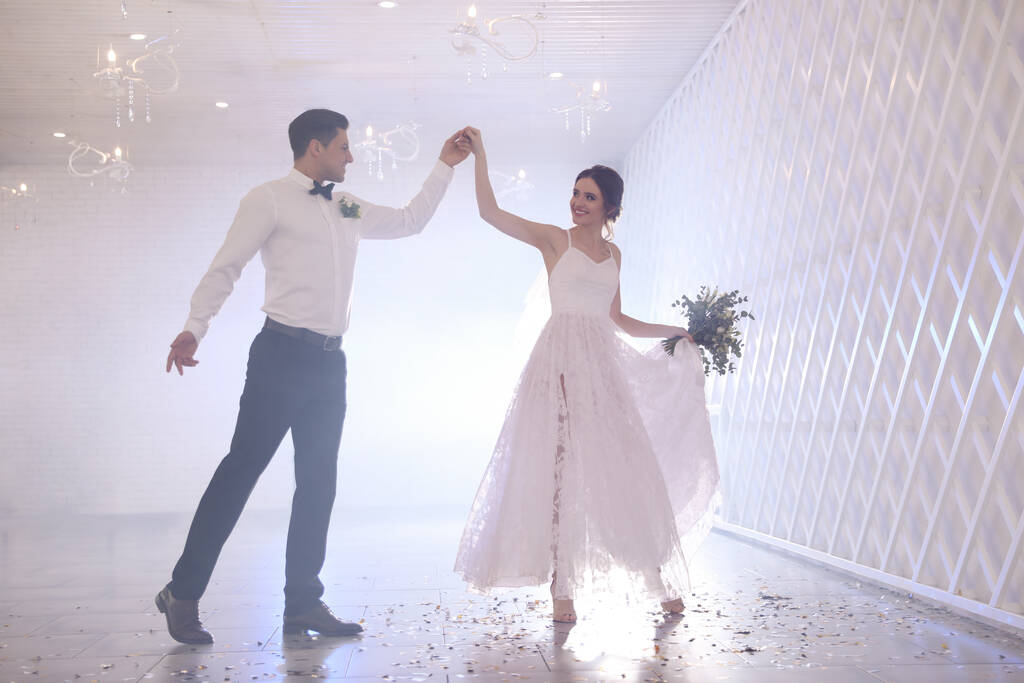 Szczęśliwa para nowożeńców tańczy razem w świątecznej sali - Zdjęcie, obraz