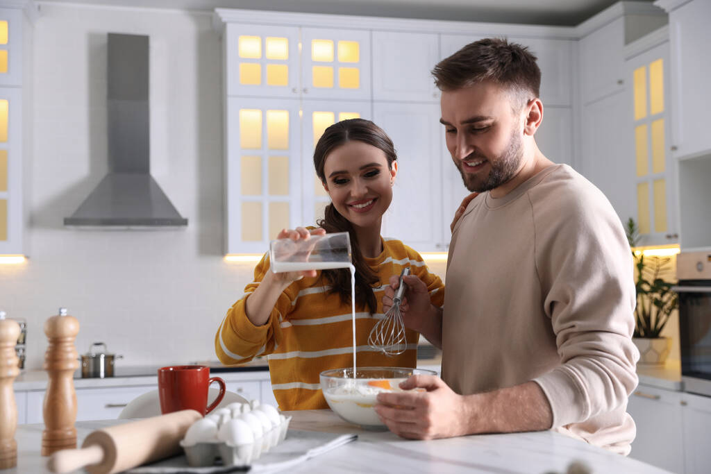 Schönes junges Paar kocht gemeinsam Teig in Küche - Foto, Bild