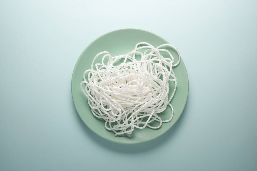 Corde blanche sur une assiette ronde. Concept de spaghetti
 - Photo, image