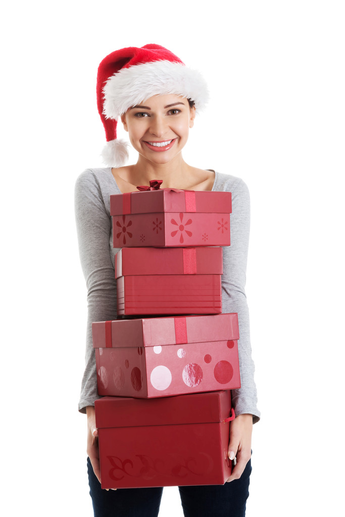 Красива жінка в капелюсі Санта тримає подарунки
. - Фото, зображення