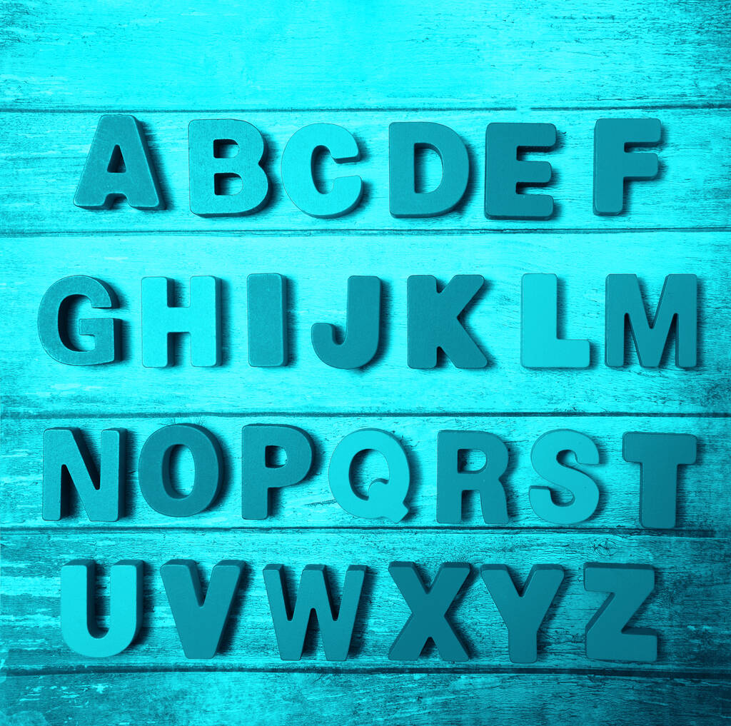 Letras de madera del alfabeto inglés en el fondo del tablero, vista superior
 - Foto, imagen