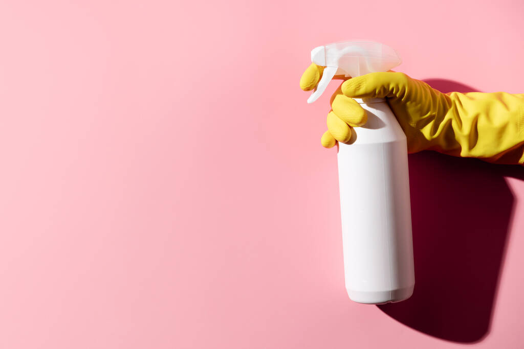 Weibliche Hände beim Putzen auf rosa Hintergrund. Hintergrund Reinigungs- oder Reinigungskonzept. - Foto, Bild