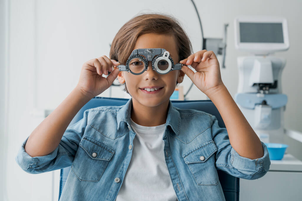 Młody chłopiec poddany badaniu wzroku z okularami w klinice medycznej - Zdjęcie, obraz
