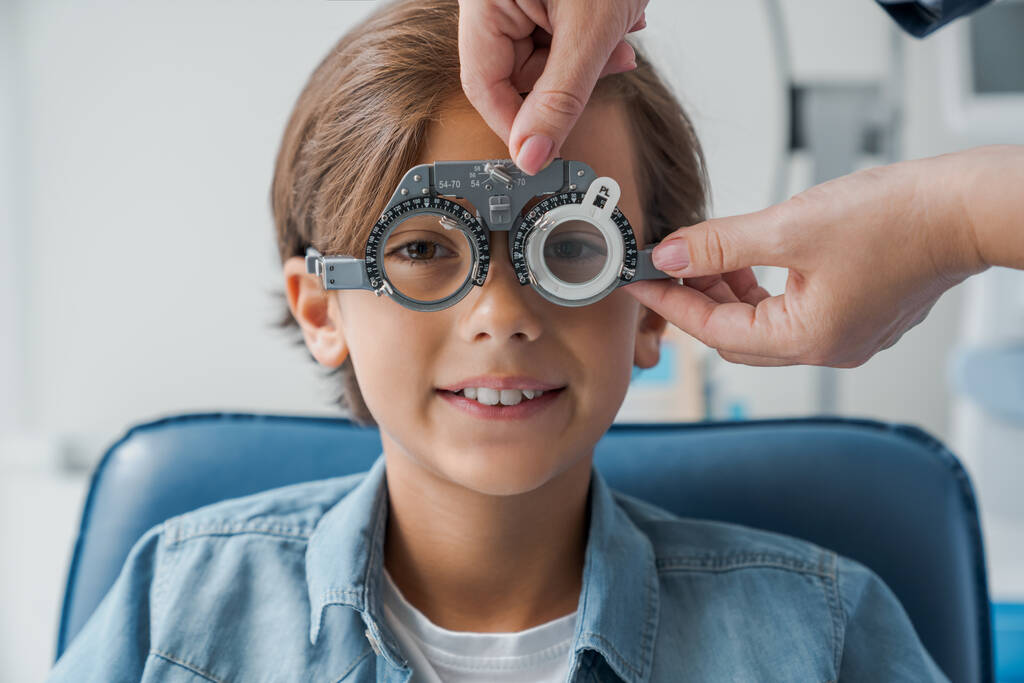 眼科診療所で視力検査をしている間、フォロパーを持つ少年。光量子概念. - 写真・画像
