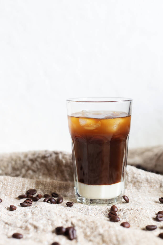 白を基調とした袋地に練乳とコーヒー豆を入れた伝統的なベトナムのアイスコーヒー。ガラスに氷のいくつかの作品は、夏の朝のための最高の飲み物。縦・横・縦 - 写真・画像