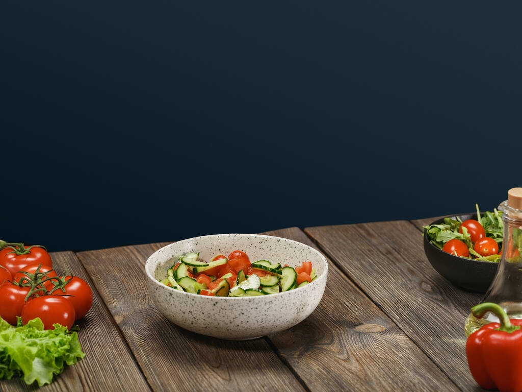 Insalata di verdure fresche in ciotola bianca su tavolo di legno su sfondo blu con copyspace. Stile di vita vegetariano sano
. - Foto, immagini
