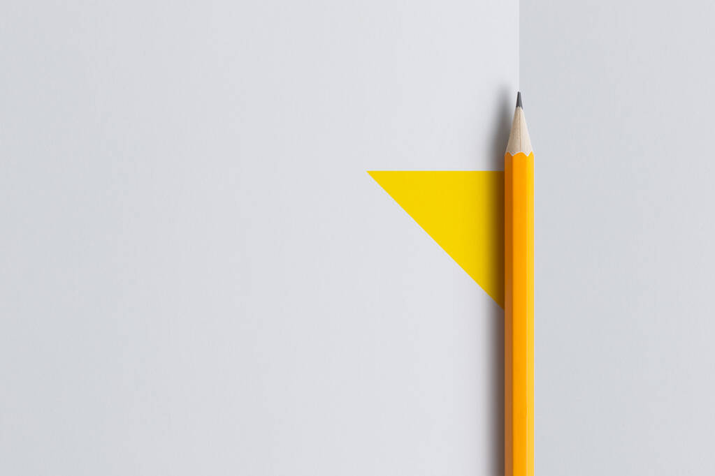 オレンジ色の鉛筆と創造的な思考(テキスト)のためのスペースのインタラクティブな写真構成は、教育、ビジネスや創造性の分野でのプレゼンテーションに使用されます。スタジオの鉛筆で照明する。黄色の白地 - 写真・画像