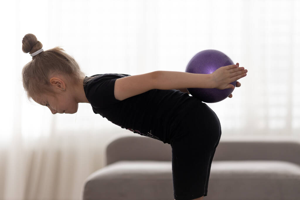 Flexible niña linda gimnasta infantil haciendo ejercicio acrobático con pelota. Deporte, entrenamiento, fitness, estilo de vida activo
 - Foto, Imagen