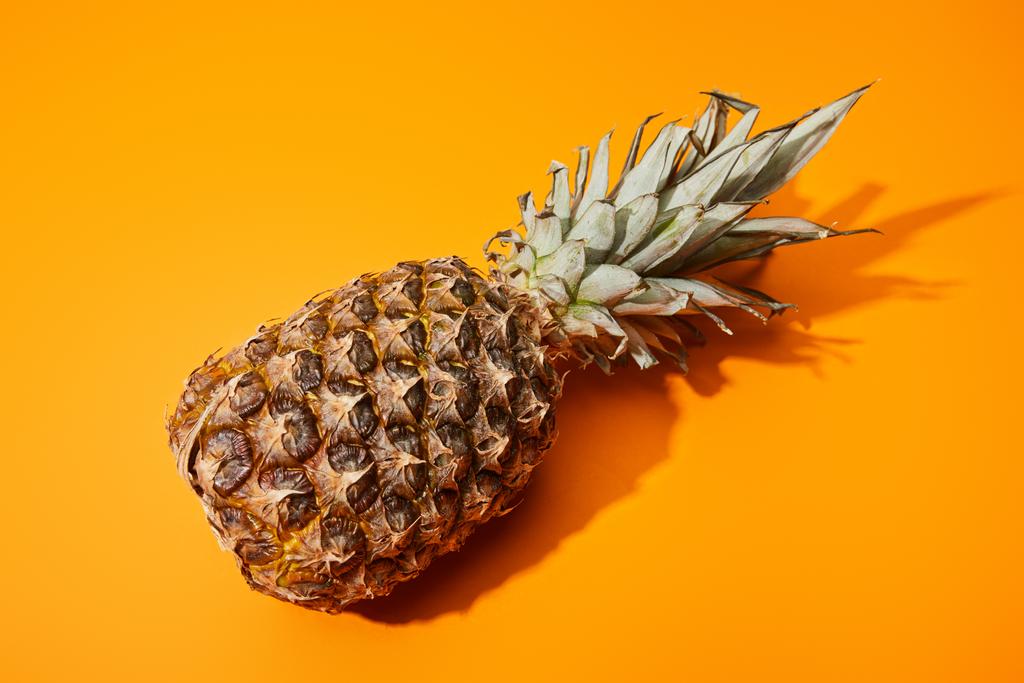 whole ripe pineapple on orange colorful background - Photo, Image