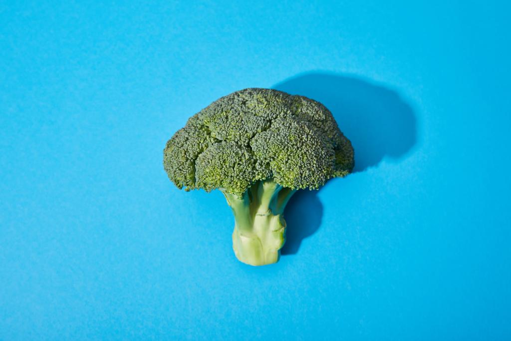 top view of fresh green broccoli on blue background - Photo, Image
