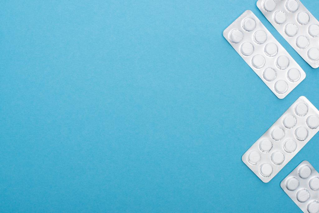 Ansicht von Pillen in Blisterverpackungen auf blauem Hintergrund - Foto, Bild