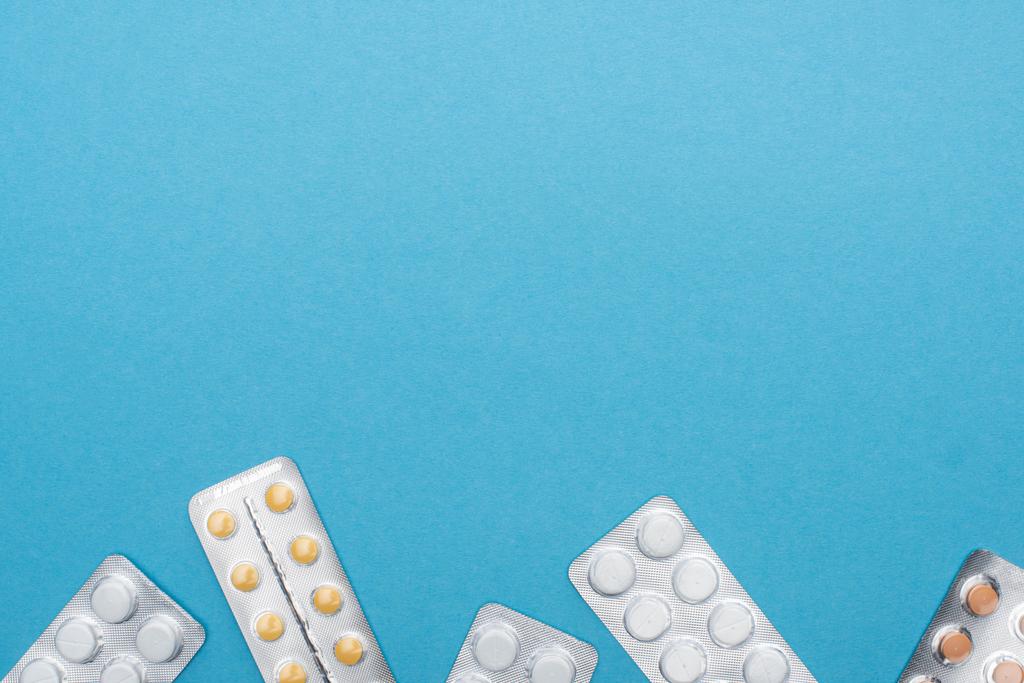 top view tabletták buborékcsomagolásban kék háttér - Fotó, kép