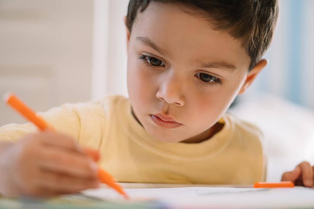 enfoque selectivo de adorable, concentrado niño dibujo con fieltro pluma
  - Foto, Imagen