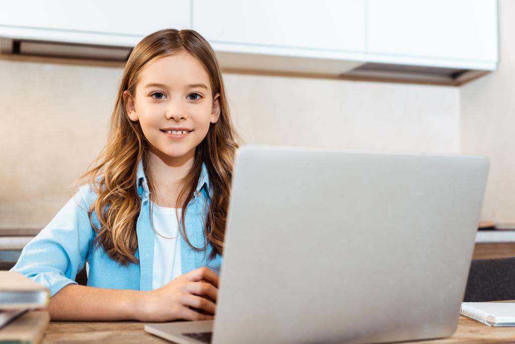 valikoiva painopiste onnellinen lapsi verkossa opiskelu lähellä kannettavaa tietokonetta kotona
 - Valokuva, kuva