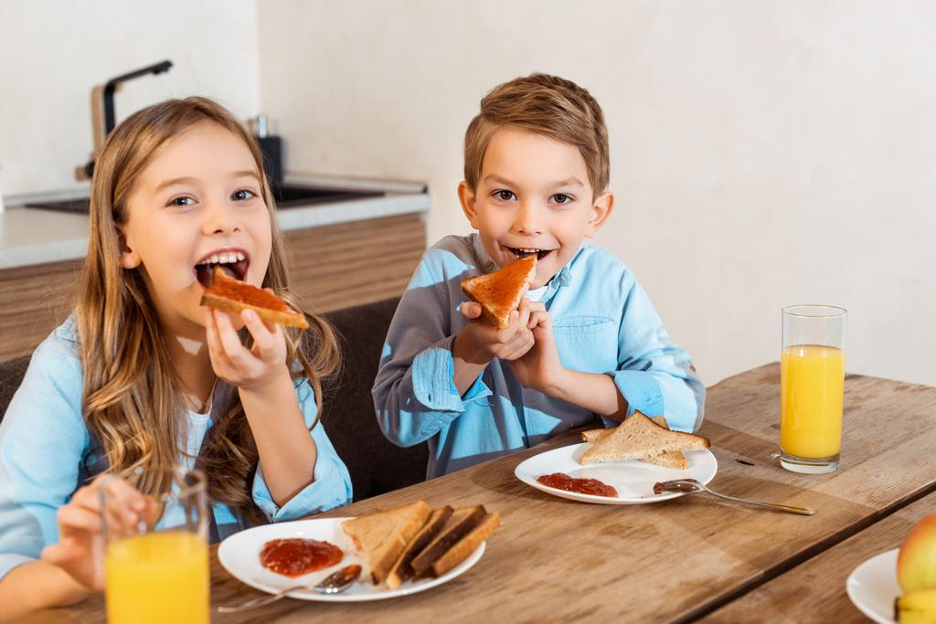 onnellisten sisarusten valikoiva keskittyminen syömällä paahtoleipää leivän kanssa
  - Valokuva, kuva