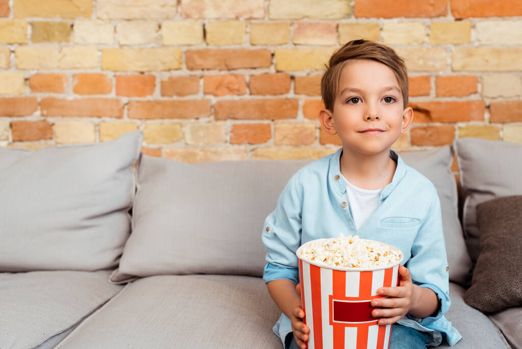 Netter Junge schaut Film und hält Popcorn-Eimer  - Foto, Bild