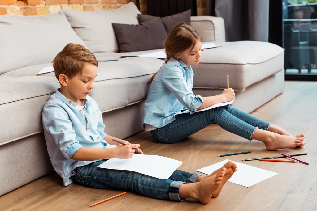 carino fratelli seduti sul pavimento e disegno in soggiorno
  - Foto, immagini