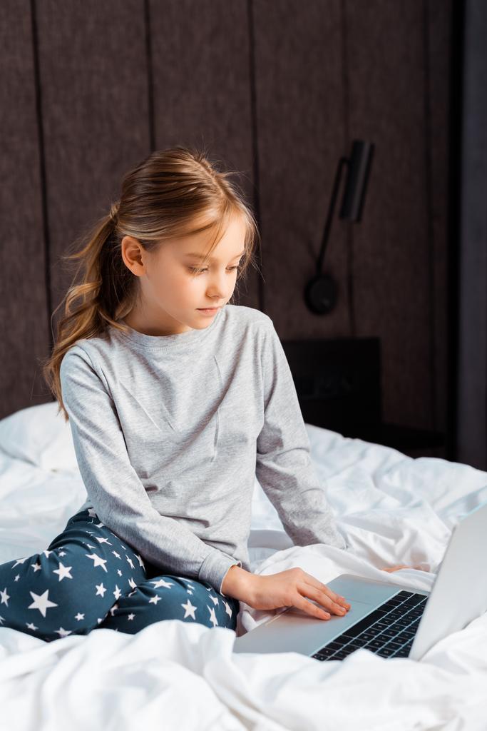 дитина використовує ноутбук з електронним навчанням у спальні
  - Фото, зображення