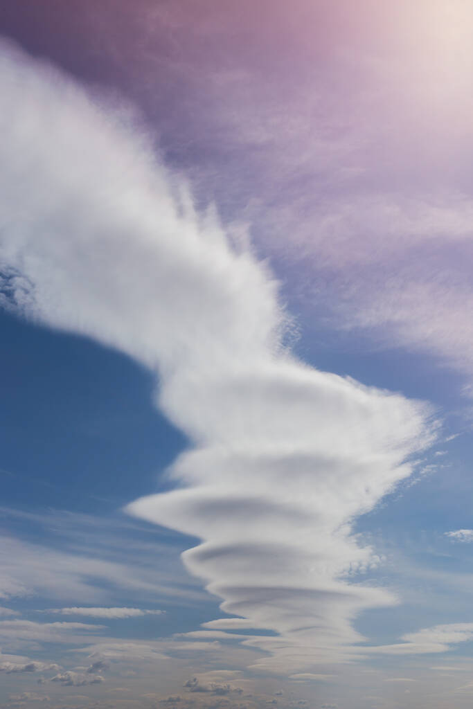 Nuvens incomuns contra um céu azul, uma nuvem na forma de uma explosão ou cogumelo, redemoinhos, vertical
 - Foto, Imagem