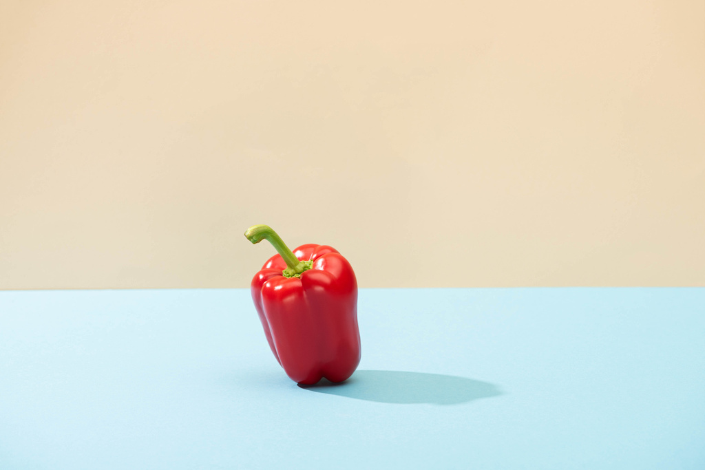 frische rote Paprika auf blauer Oberfläche isoliert auf beige - Foto, Bild