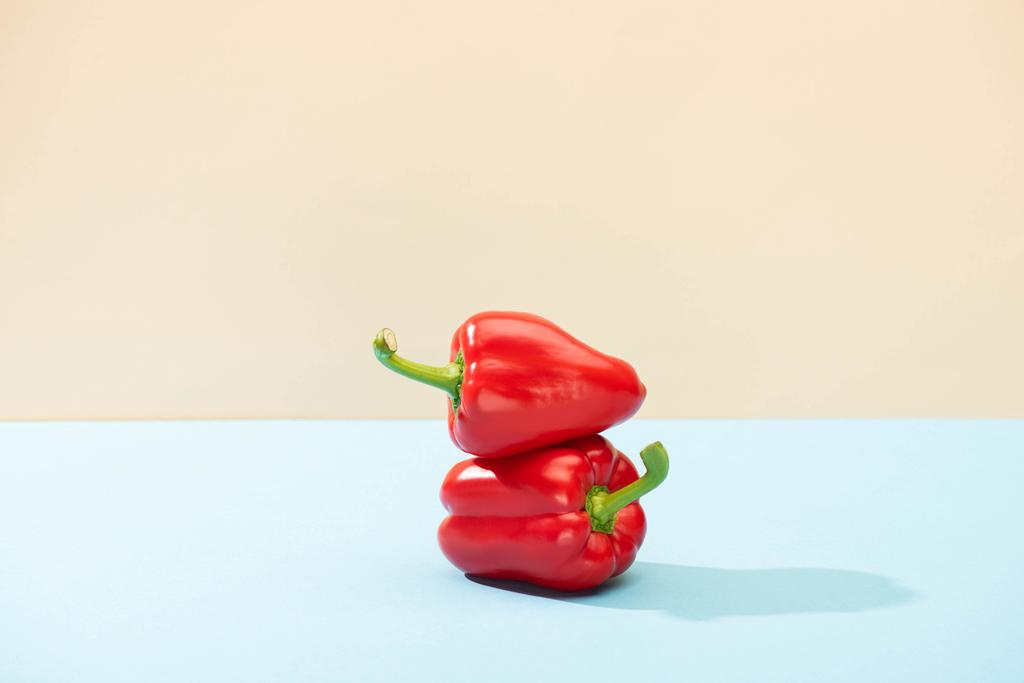 fresh red bell peppers on blue surface isolated on beige - Photo, Image