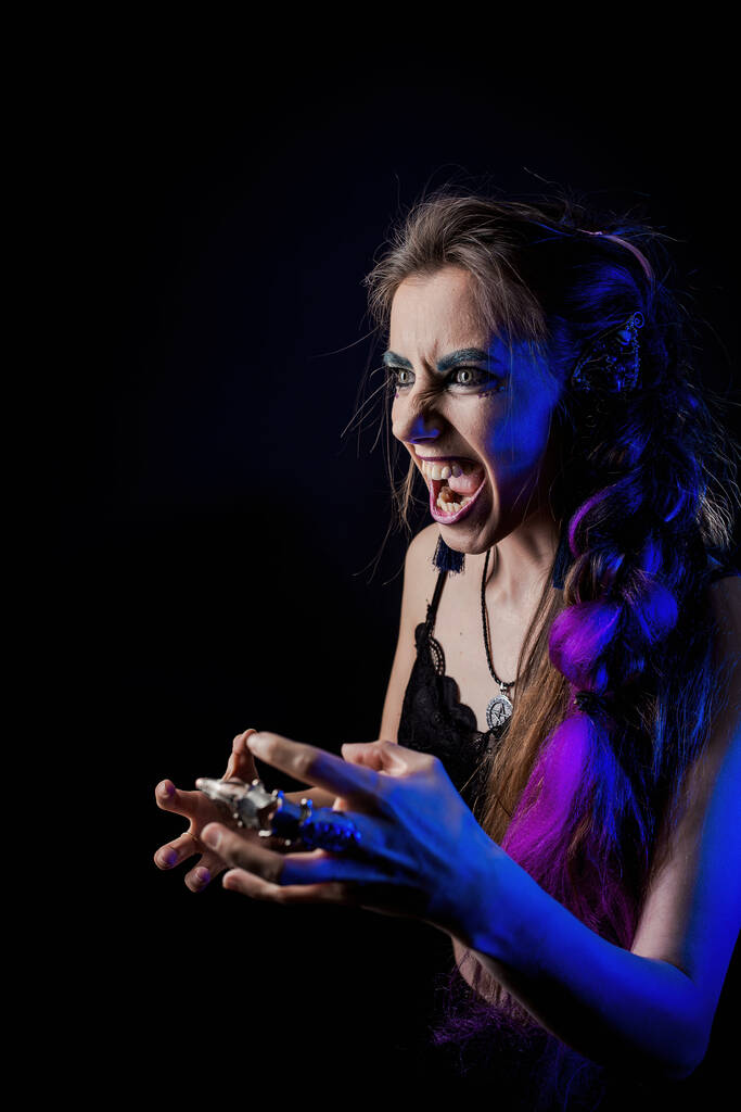 Meisje in weerwolfstijl op een zwarte achtergrond met blauw licht - Foto, afbeelding
