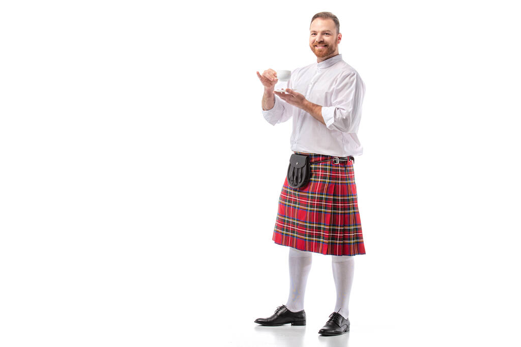 souriant écossais rousse homme en kilt rouge boire du café sur fond blanc
 - Photo, image