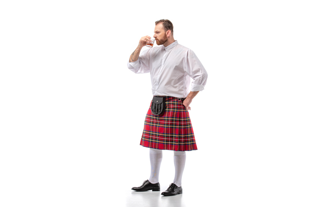 Szkocki rudzielec w czerwonym kilcie pachnący whisky na białym - Zdjęcie, obraz