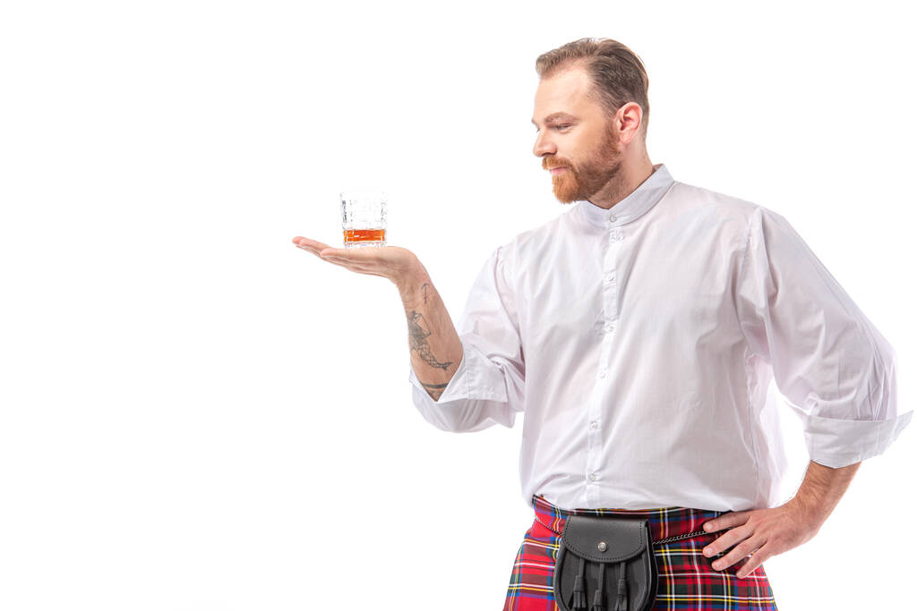Écossais rousse homme en kilt rouge avec whisky en verre à la main isolé sur blanc
 - Photo, image