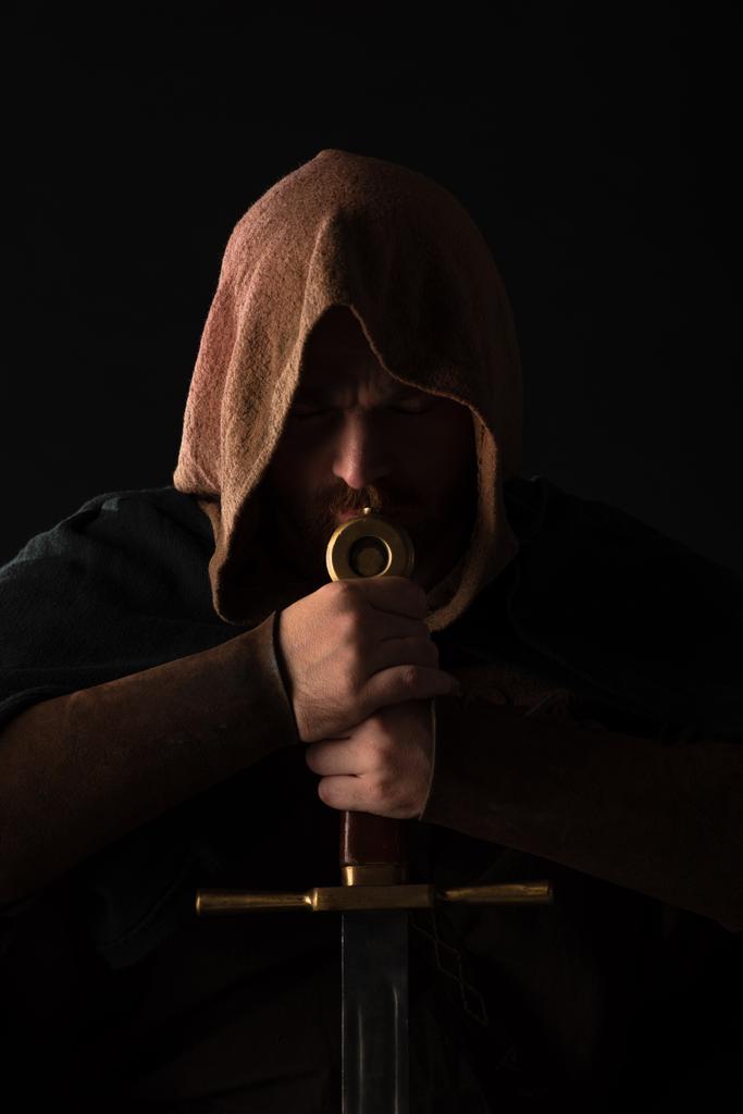 средневековый шотландский человек в камине с мечом в темноте изолированы на черном
 - Фото, изображение