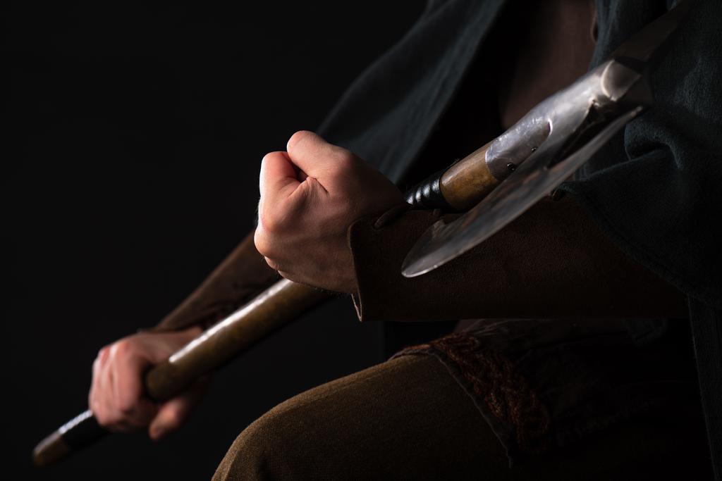 黒に隔離された手に戦闘斧を持つ中世スコットランドの戦士のクロップドビュー - 写真・画像