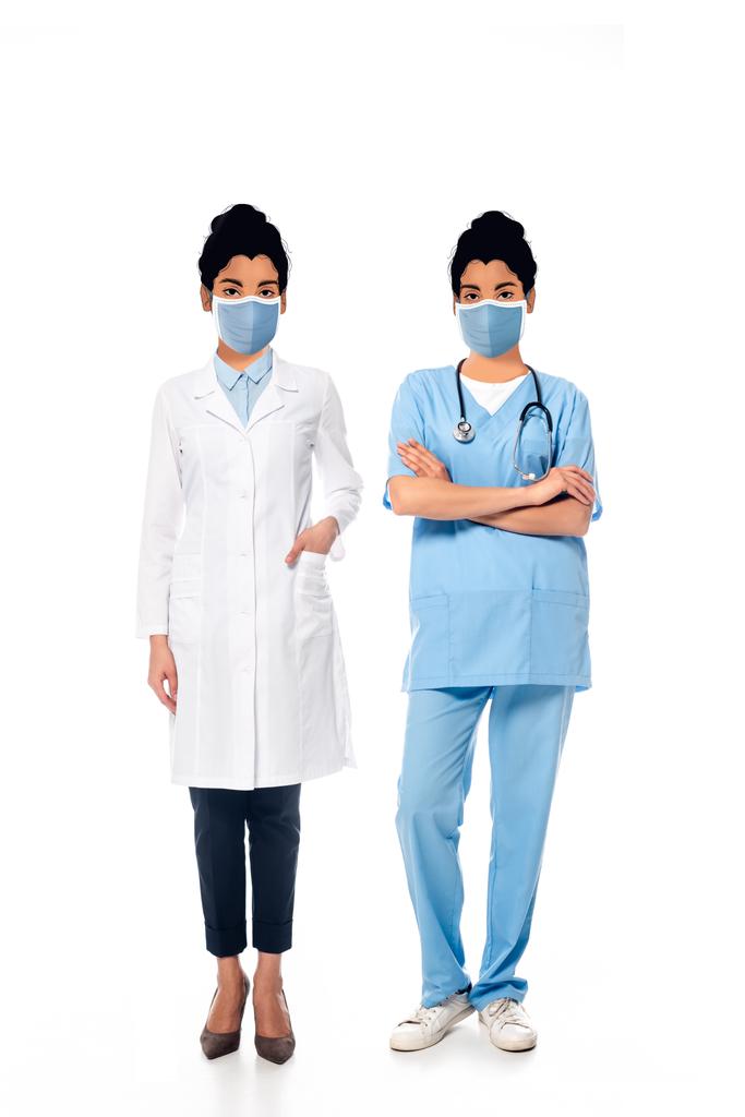 infirmière afro-américaine et médecin avec des visages illustrés dans des masques médicaux sur blanc
 - Photo, image