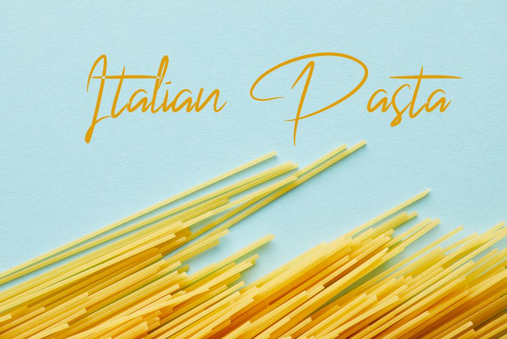 Draufsicht auf rohe Spaghetti auf blauem Hintergrund mit italienischer Pasta-Illustration - Foto, Bild