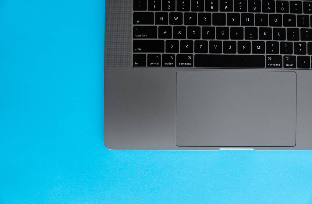 Billentyűzet egy ezüst laptop, hogy feküdt a kék háttér. - Fotó, kép