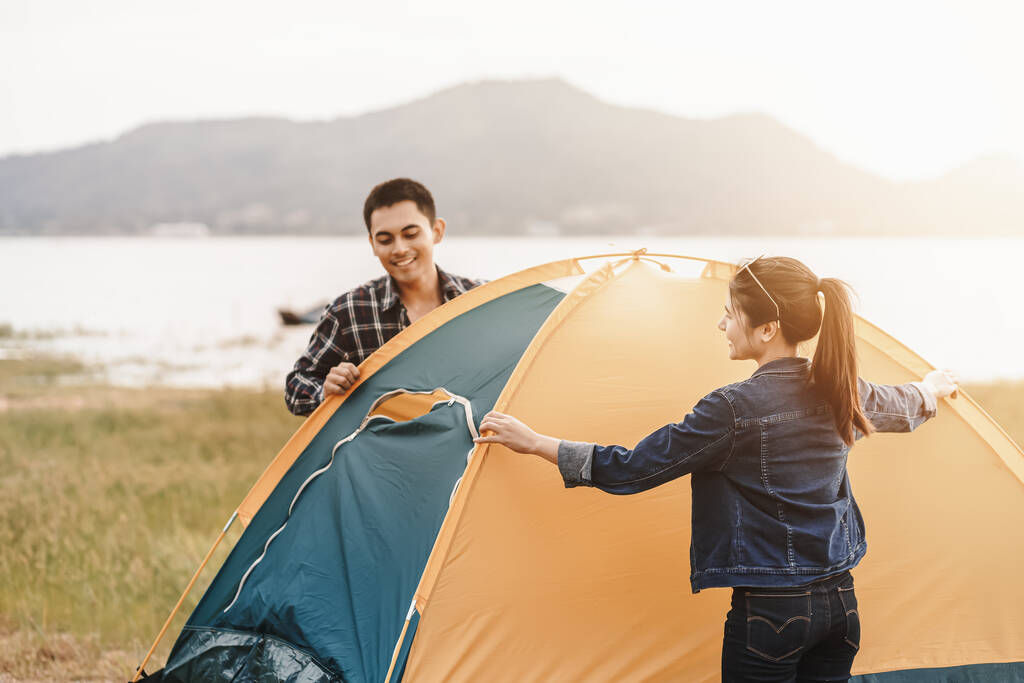 Menschen schlagen ein Zelt auf dem Boden in der Nähe des Sees auf. Entspannen, Reisen, lange Reisen, Urlaubskonzept. - Foto, Bild