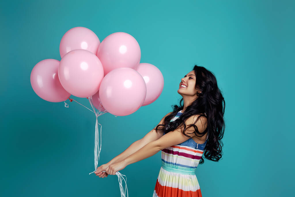 κορίτσι με φόρεμα κρατώντας παστέλ ροζ μπαλόνια αέρα - Φωτογραφία, εικόνα