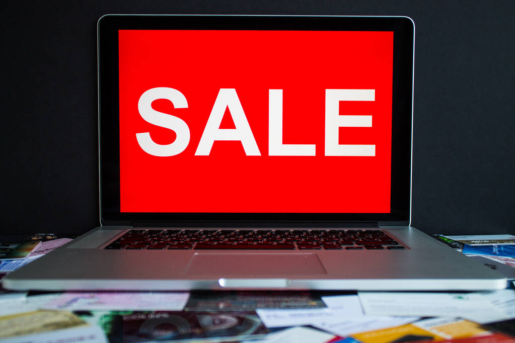 Rote Papiertüte für Computer-Nahaufnahmen und die Beschriftung auf dem Bildschirm - Verkauf auf hellem Hintergrund. Das Konzept des Online-Shoppings - Foto, Bild