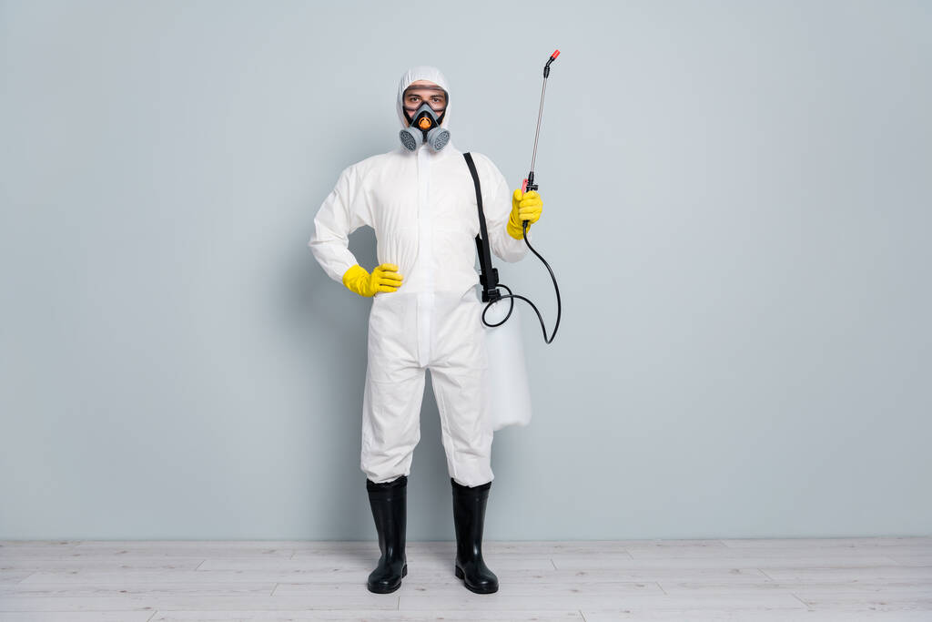 Salgın uzmanı erkek dezenfektanının tam boy fotoğrafı. Salgın sırasında halka açık yerleri temizlemeye başlayın. Salgın hastalık spreyinde beyaz koruyucu elbise giyin. - Fotoğraf, Görsel