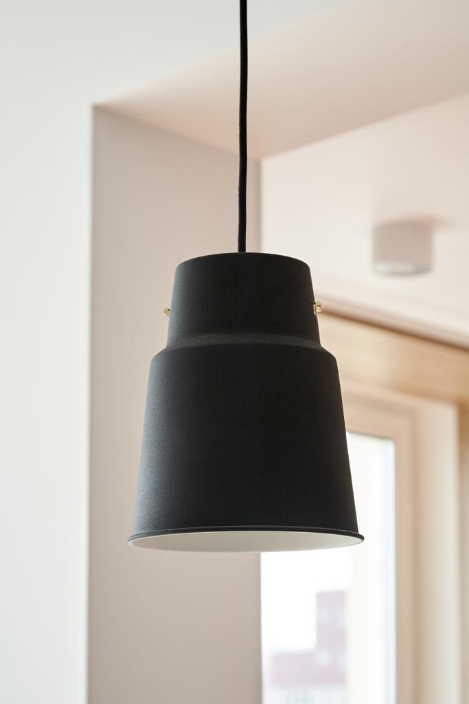 černá lampa visí v blízkosti bílých stěn v bytě  - Fotografie, Obrázek