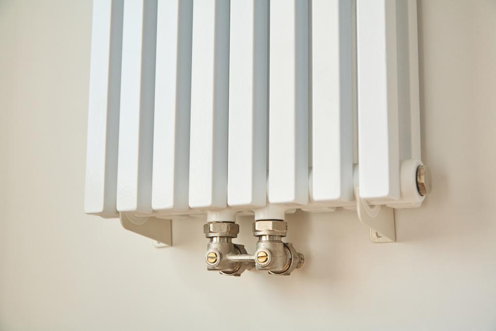 moderne verwarming radiator in de buurt van witte muur in appartement  - Foto, afbeelding
