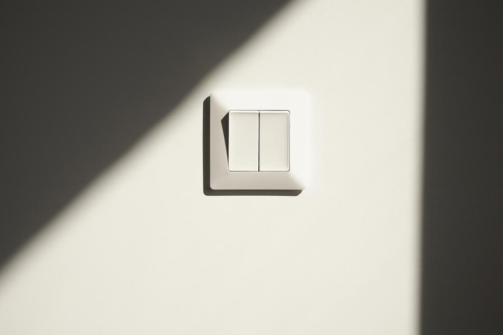 ηλιοφάνεια σε λευκό διακόπτη στον τοίχο στο διαμέρισμα  - Φωτογραφία, εικόνα