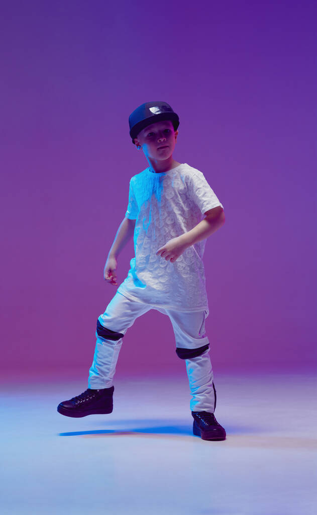 Cool young boy child dancing hip hop in the Studio against the background of neon lights. Break dance poster. - Photo, Image