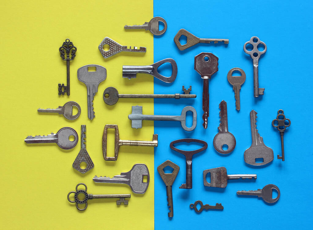 various metal keys on a blue-yellow background, top view. flat lay. - Photo, Image