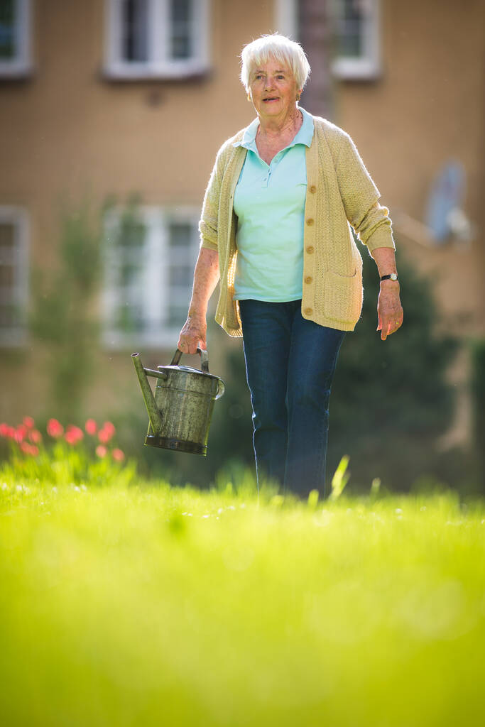 Mujer mayor haciendo jardinería en su precioso jardín
 - Foto, Imagen