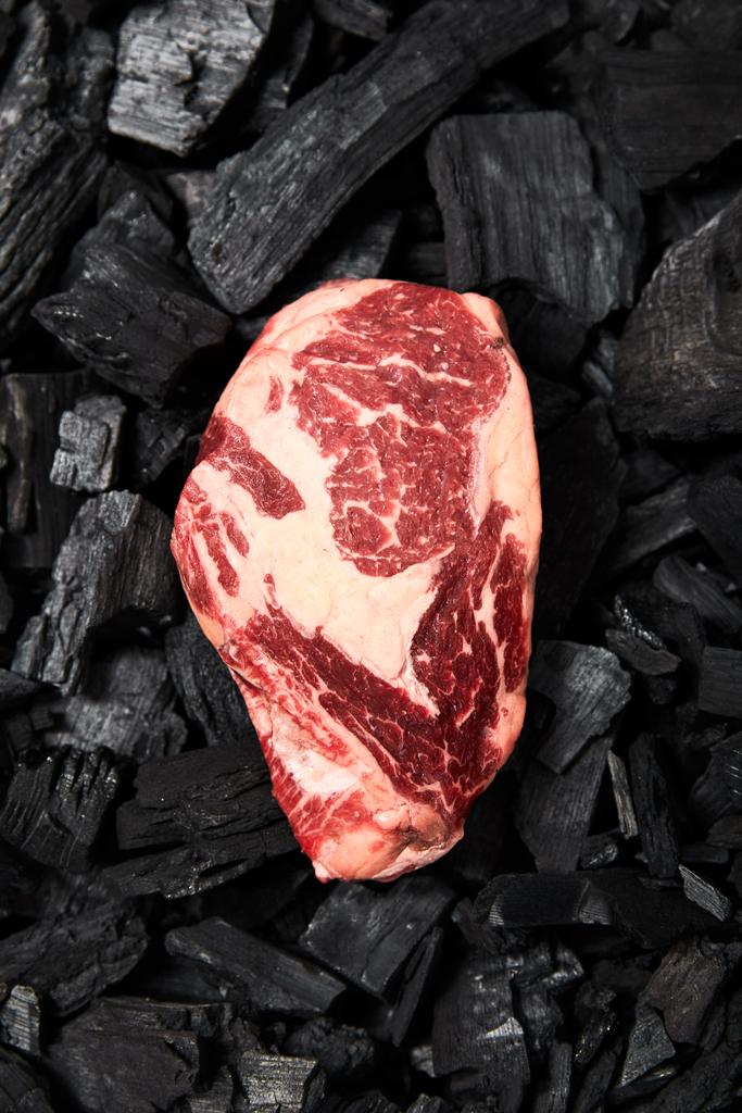 黒炭の上からの新鮮な生ステーキの眺め - 写真・画像