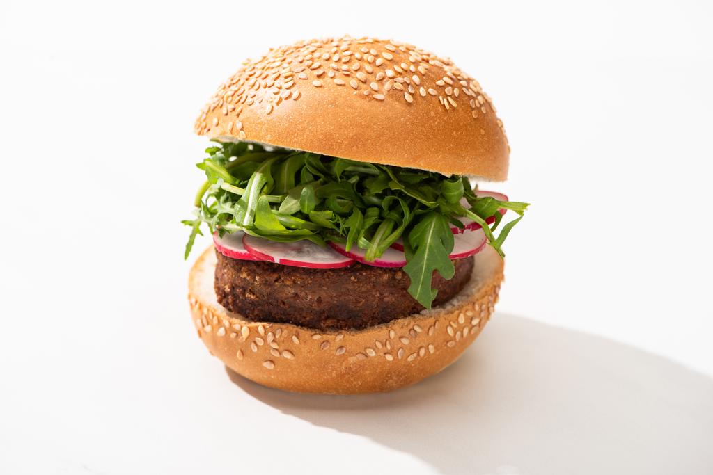 leckerer veganer Burger mit Rettich und Rucola auf weißem Hintergrund - Foto, Bild